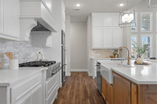 a kitchen with stainless steel appliances a sink stove and cabinets