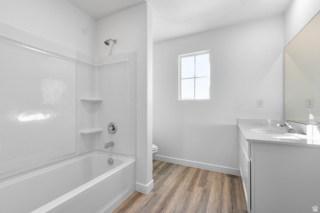788 West 2840 South, Unit 2 Logan, UT 84321 - Photo 14 of 21 Bathroom featuring a shower-over-tub combination with white surround, a window providing ambient light, wood-finish flooring, a white vanity with a light-colored countertop, and a large wall-mounted mirror