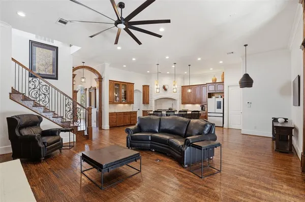 a living room with furniture kitchen view and a wooden floor