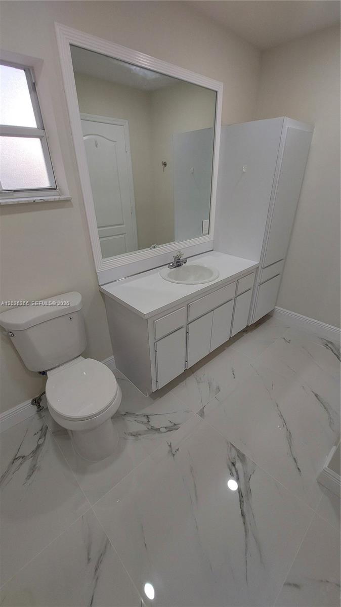 7083 Southwest 158th Court Miami, FL 33193 - Photo 15 of 22 a bathroom with a toilet sink and mirror