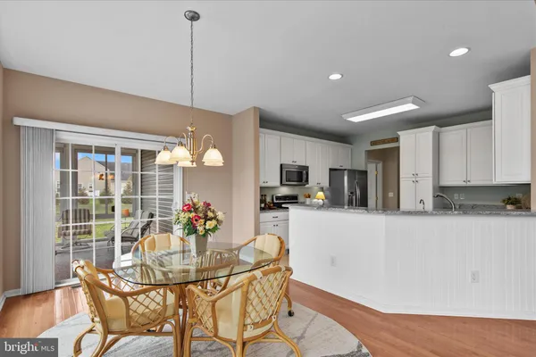 a dining room with furniture a kitchen island and a chandelier