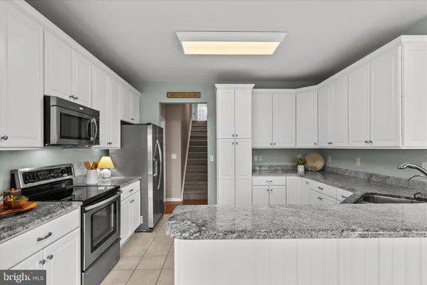 a kitchen with refrigerator a stove a microwave and cabinets