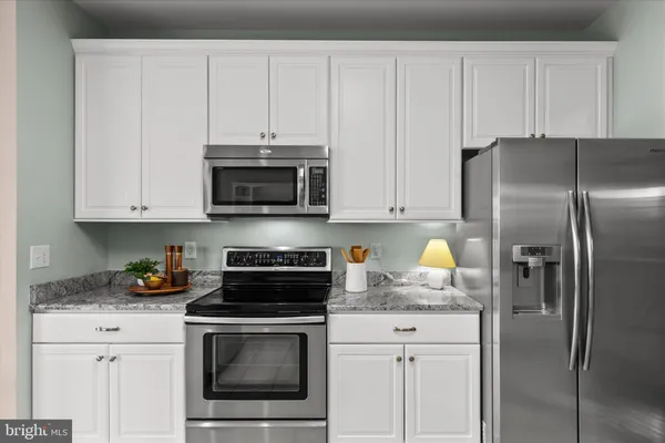 a kitchen with granite countertop white cabinets and sink
