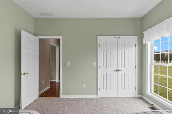 a bedroom with a bed and a large window