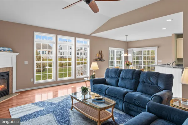 a living room with furniture a fireplace and a large window