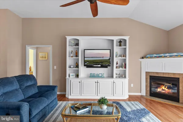 a living room with furniture kitchen view and a chandelier