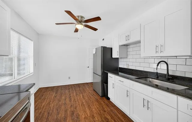 a kitchen with granite countertop a sink stainless steel appliances and cabinets