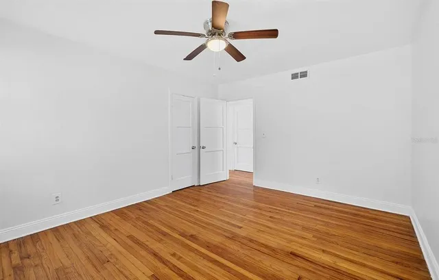 a view of room with wooden floor and ceiling fan
