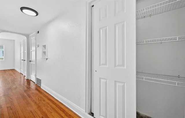 a view of a hallway with wooden floor
