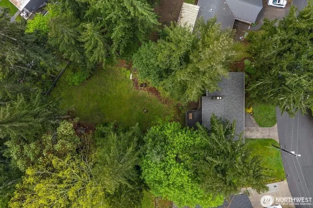 an aerial view of residential house with outdoor space and trees all around