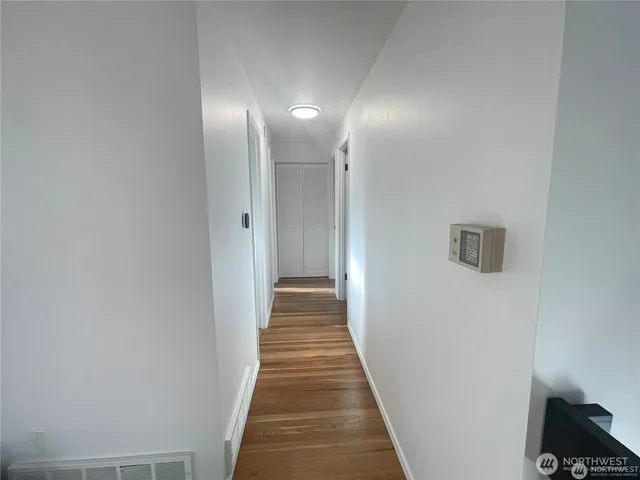 a view of a hallway with wooden floor and staircase
