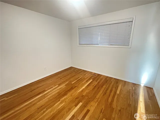 a view of a room with wooden floor and a window