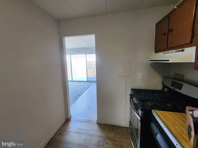a kitchen with wooden floor and a stove top oven