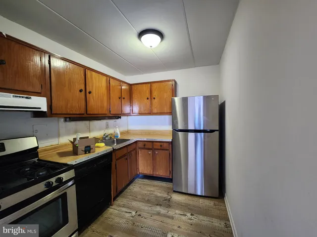 a kitchen with stainless steel appliances granite countertop a refrigerator a stove a sink and a microwave