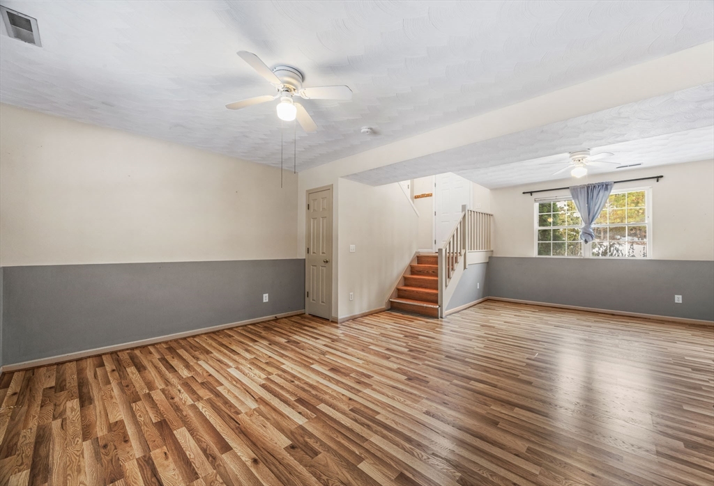 305 Raymond Road Plymouth, MA 02360 - Photo 20 of 29 an empty room with wooden floor staircase and windows
