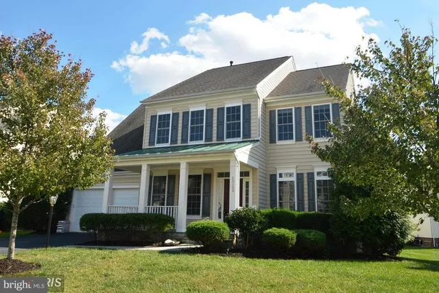 a front view of a house with a yard and potted plants