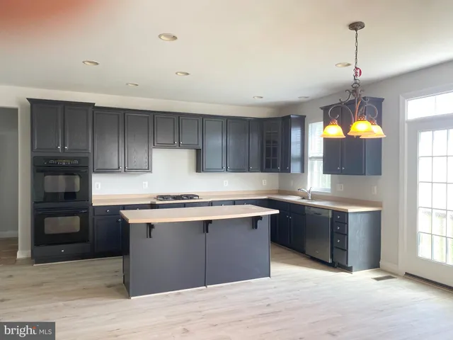 a kitchen with stainless steel appliances granite countertop a stove sink and cabinets