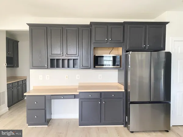 a kitchen with stainless steel appliances granite countertop a refrigerator and a stove top oven