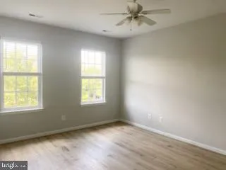 an empty room with a window and ceiling fan