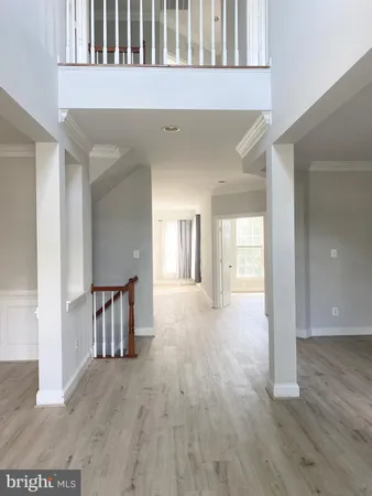 a view of a hallway with wooden floor and windows