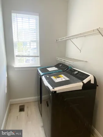 a utility room with dryer and window