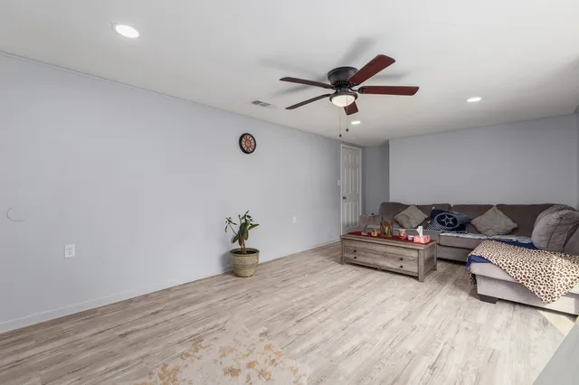a living room with furniture and a ceiling fan