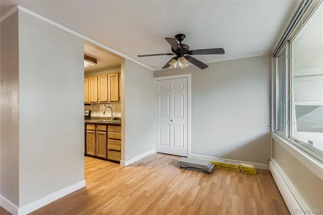 a view of empty room with wooden floor and fan