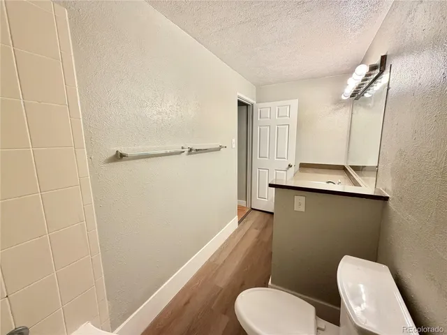 a bathroom with a granite countertop sink toilet and shower