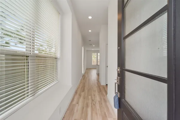 a view of a hallway with wooden floor and staircase