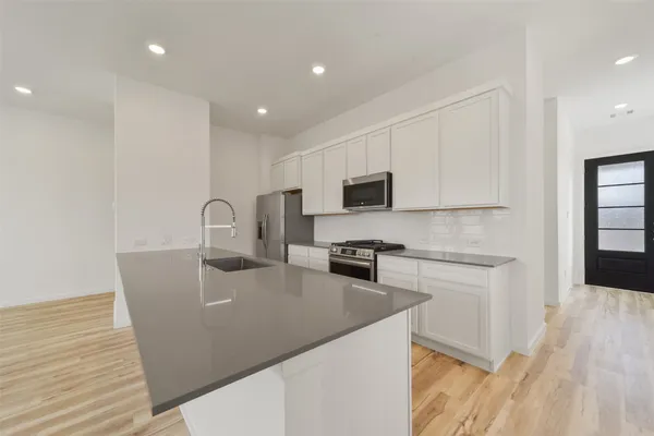 a kitchen with stainless steel appliances granite countertop a refrigerator a stove top oven a sink and dishwasher