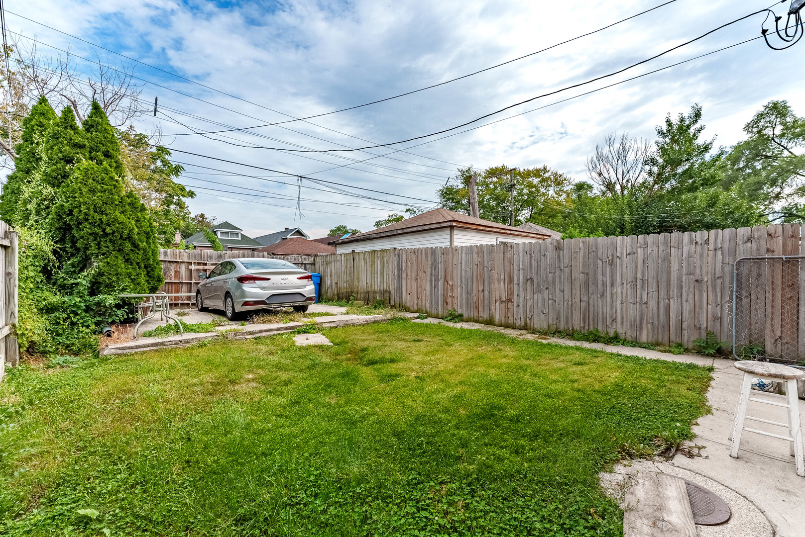 7149 South Wood Street Chicago, IL 60636 - Photo 25 of 26 a view of a backyard with table and chairs potted plants and wooden fence