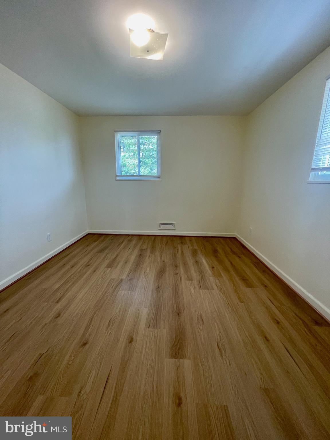 12505 Feldon Street Silver Spring, MD 20906 - Photo 11 of 32 an empty room with wooden floor and windows