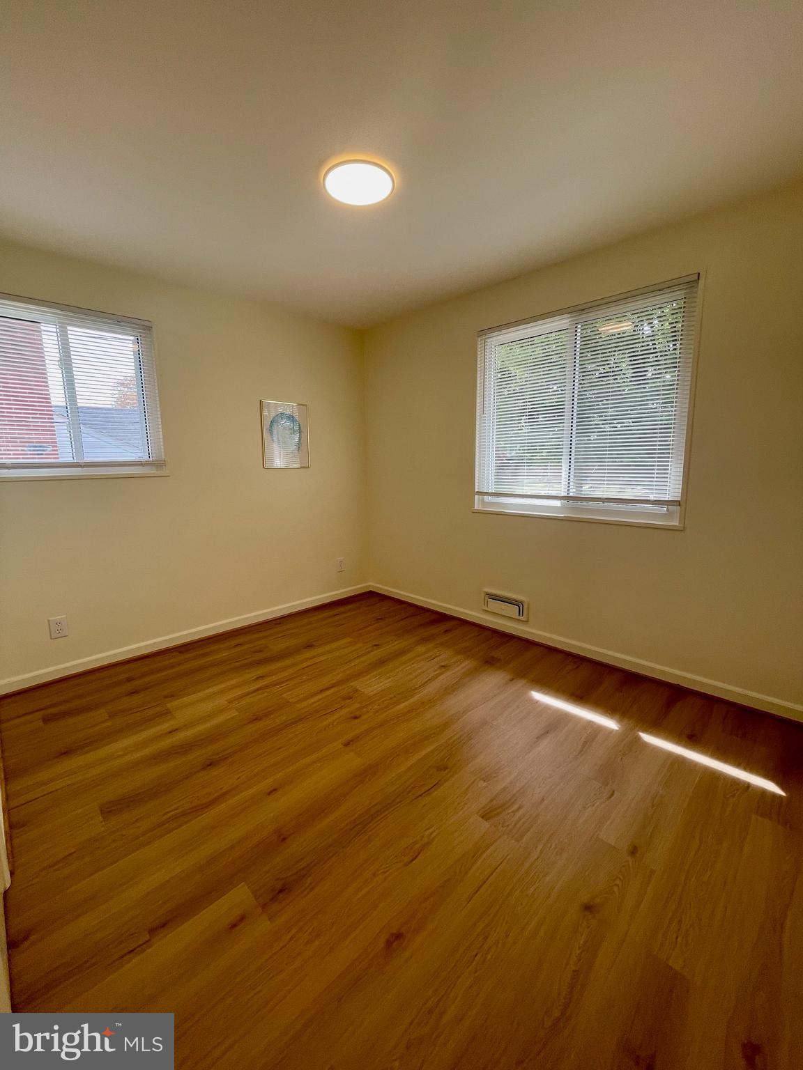 12505 Feldon Street Silver Spring, MD 20906 - Photo 12 of 32 a view of an empty room with wooden floor and a window