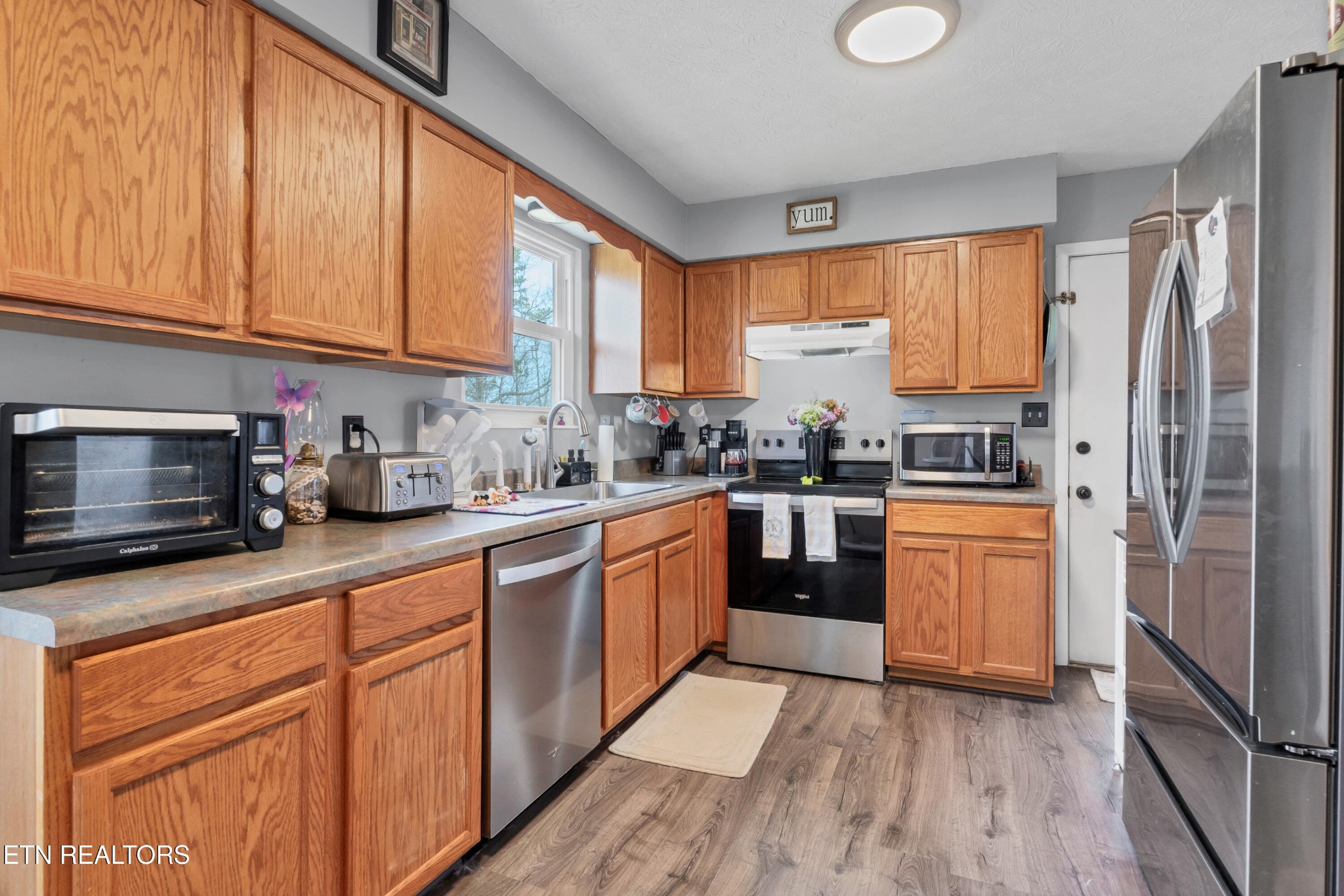926 Amy Street Seymour, TN 37865 - Photo 7 of 22 a kitchen with stainless steel appliances granite countertop a refrigerator a sink dishwasher a stove and white cabinets with wooden floor