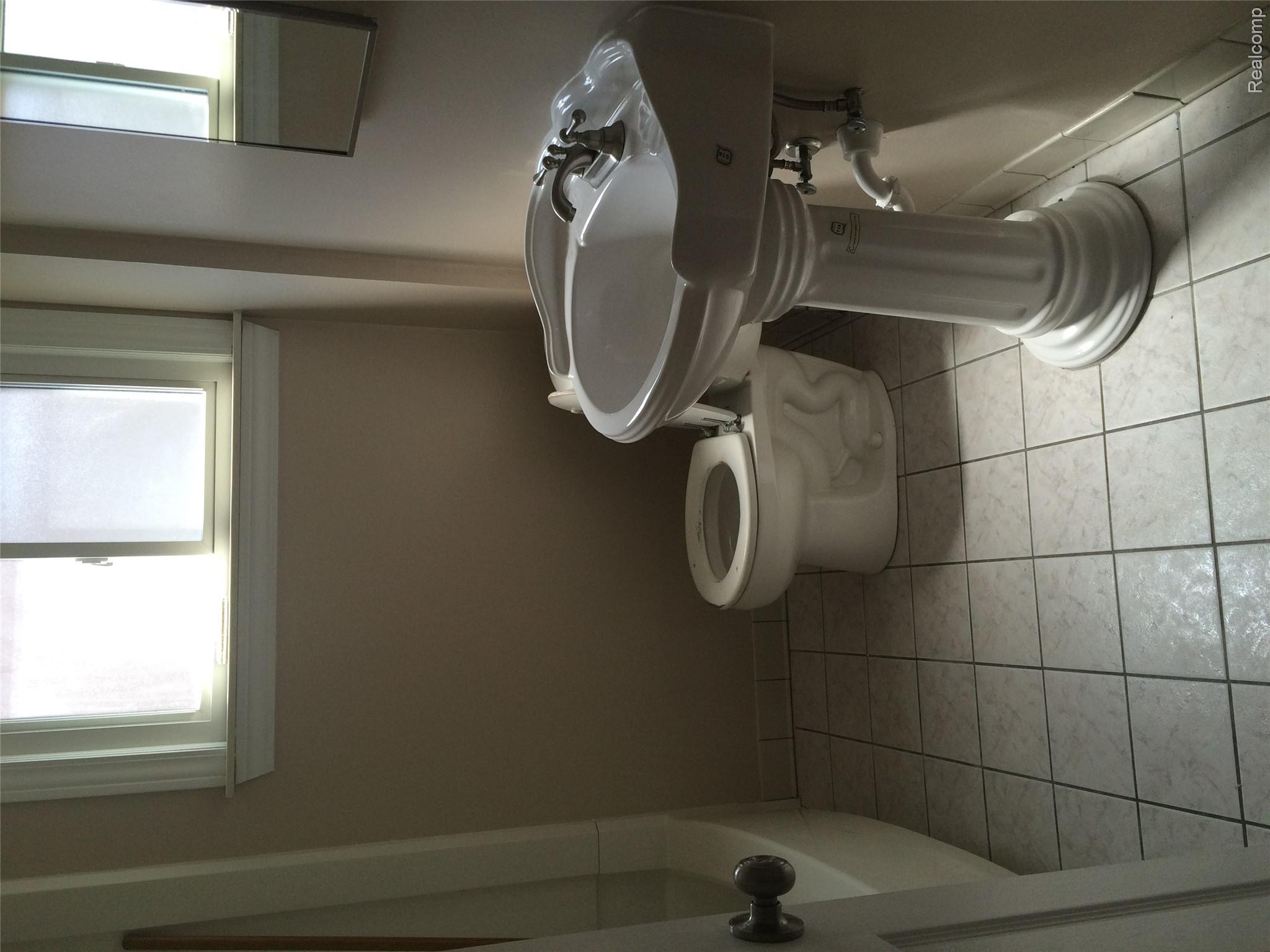 30057 Spring Arbor Drive Inkster, MI 48141 - Photo 9 of 9 Bathroom featuring a pedestal sink with chrome fixtures, a toilet, and a bathtub