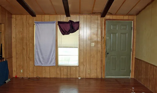 an empty room with wooden floor and a window