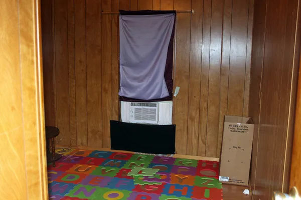 a bedroom with a bed and a lamp on dresser