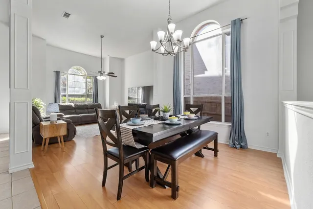 a view of a dining room with furniture a chandelier and wooden floor