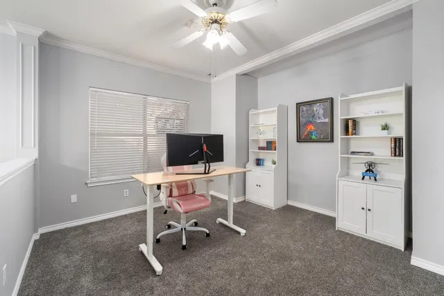 a view of a workspace with furniture and a window