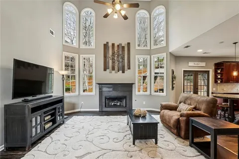 a living room with furniture a flat screen tv and a fireplace