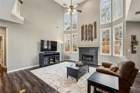 a living room with furniture kitchen view and a wooden floor