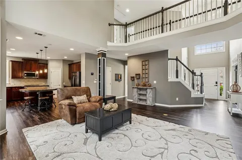 a living room with furniture a flat screen tv and kitchen view