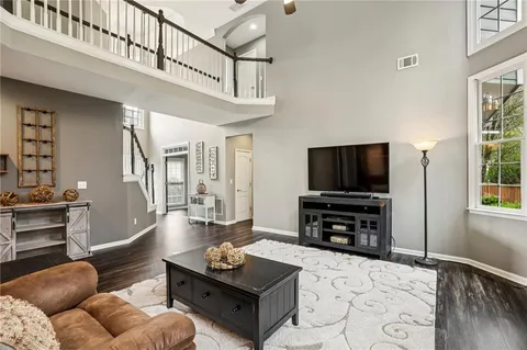 a kitchen with stainless steel appliances granite countertop a kitchen island hardwood floor sink stove dining table and chairs