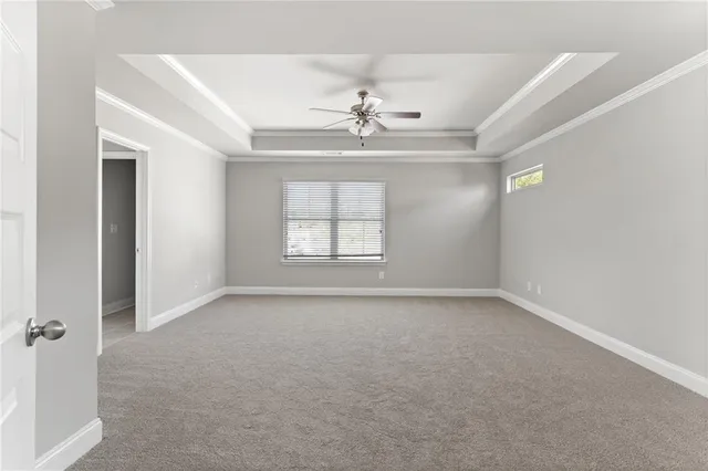 an empty room with windows and ceiling fan