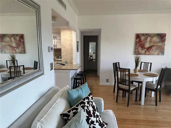 a view of a dining room with furniture a rug and wooden floor