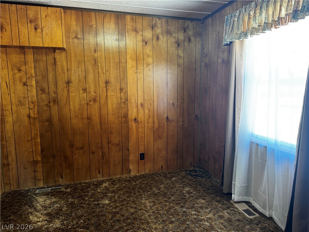 3090 Gally Road Pahrump, NV 89060 - Photo 12 of 20 Wood paneling and rich, brown carpeting define this cozy bedroom space.
