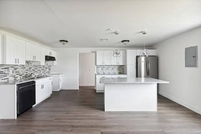a large kitchen with cabinets wooden floor and stainless steel appliances