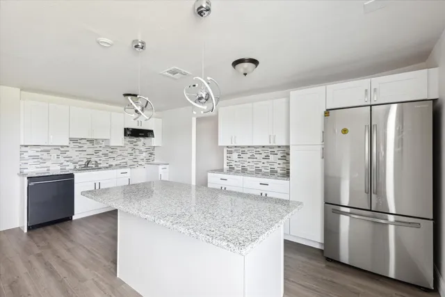 a kitchen with kitchen island granite countertop appliances and cabinets