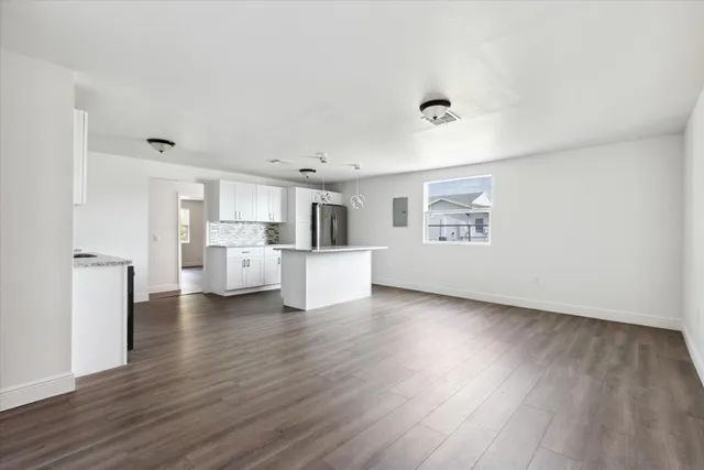 a view of a kitchen with wooden floor and a window