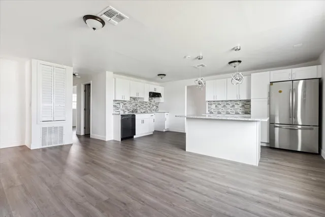 a view of kitchen with stainless steel appliances refrigerator stove microwave and cabinets